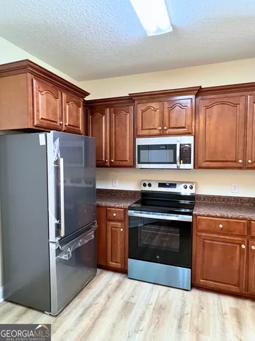 a kitchen with stainless steel appliances granite countertop a stove microwave and refrigerator