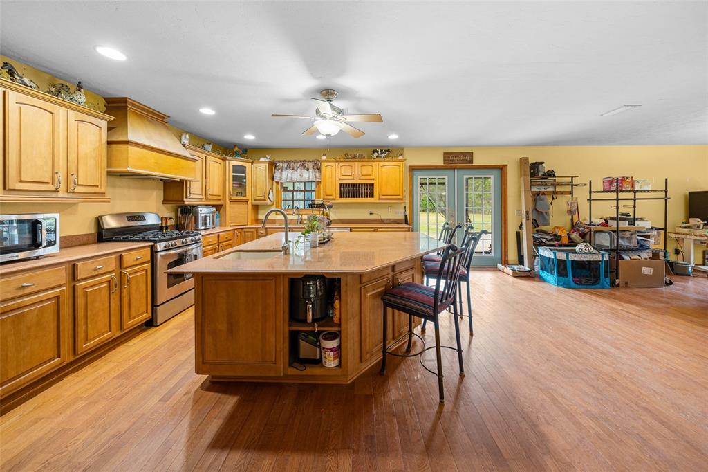 732 Carl Wilson Road Fort White, FL 32038 - Photo 4 of 80 a kitchen with stainless steel appliances granite countertop a stove top oven a sink a dining table and chairs with wooden floor