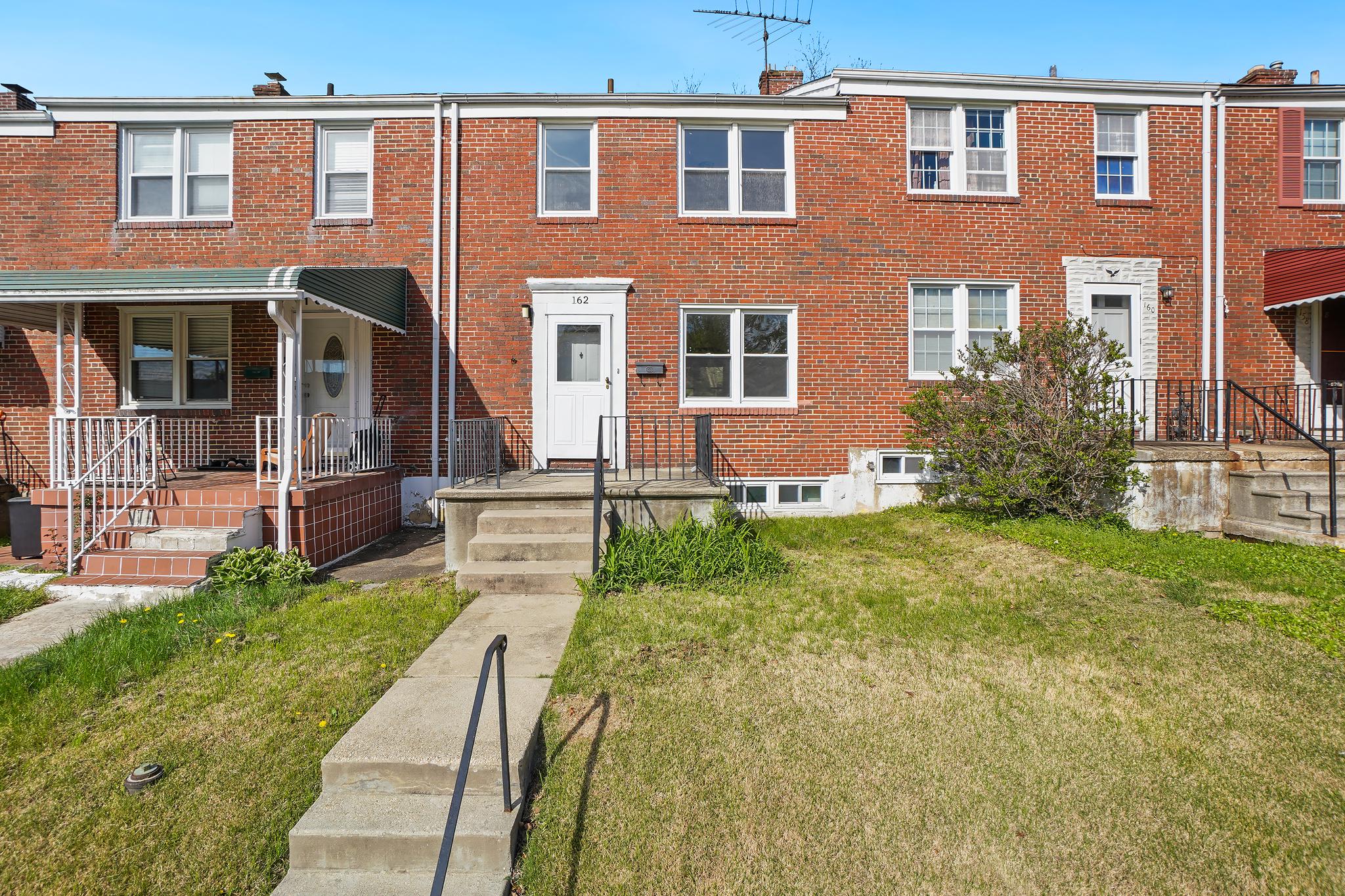 front view of a brick house with a yard