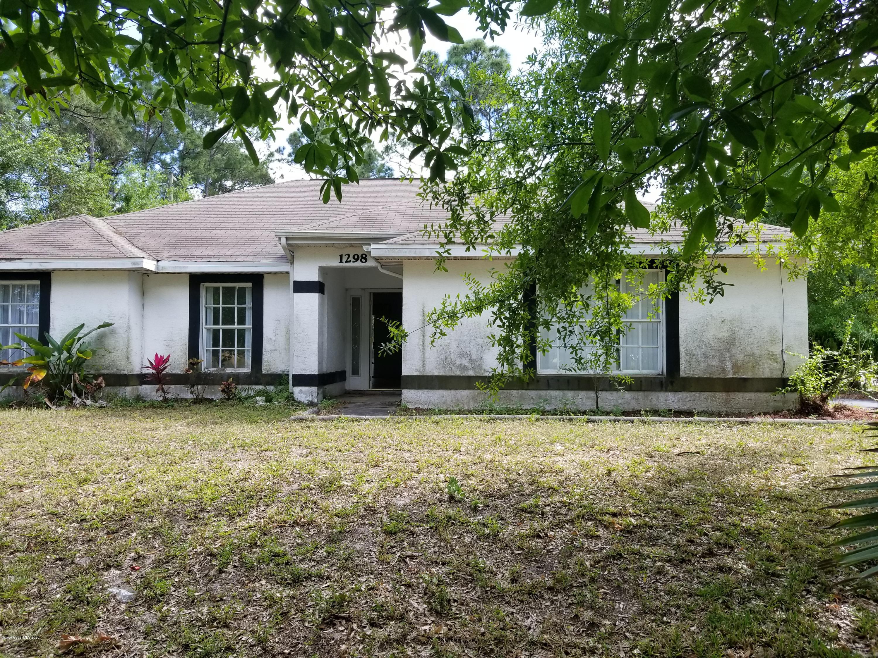 1298 Southwest Malabar Road Palm Bay, FL 32908 - Photo 1 of 9 a front view of a house with garden