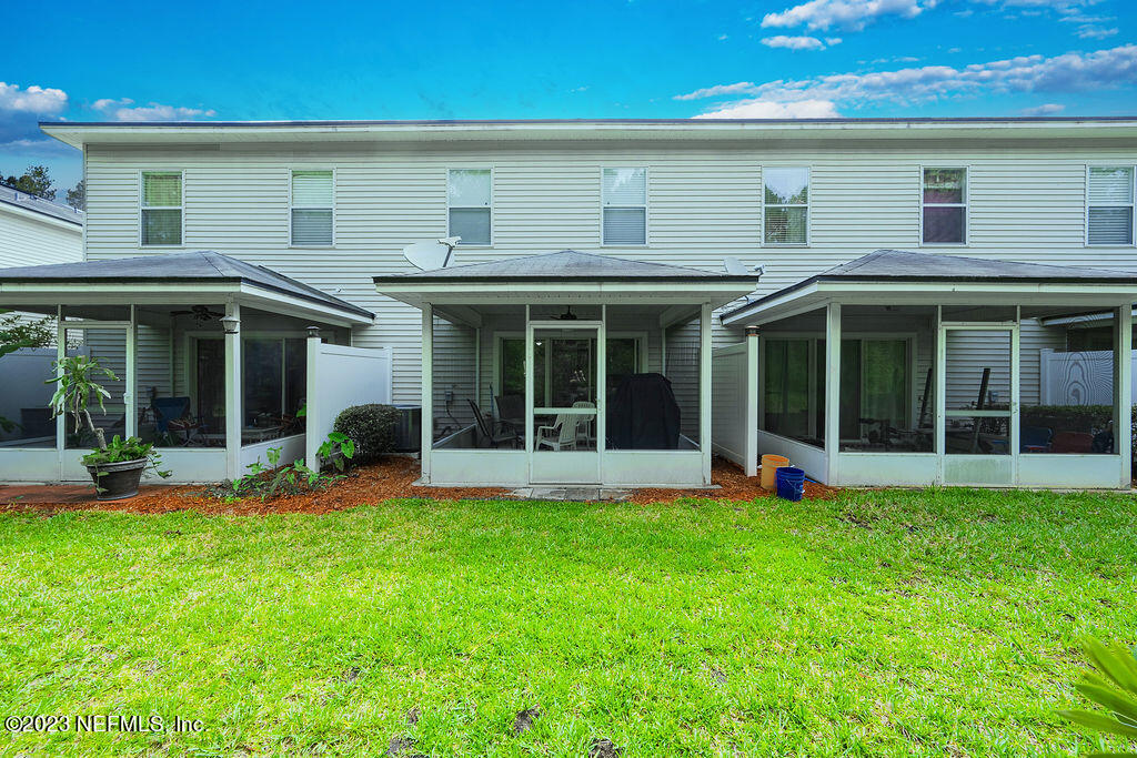 8683 Ribbon Falls Lane Jacksonville, FL 32244 - Photo 13 of 43 a view of a white house with a large garden with a large windows