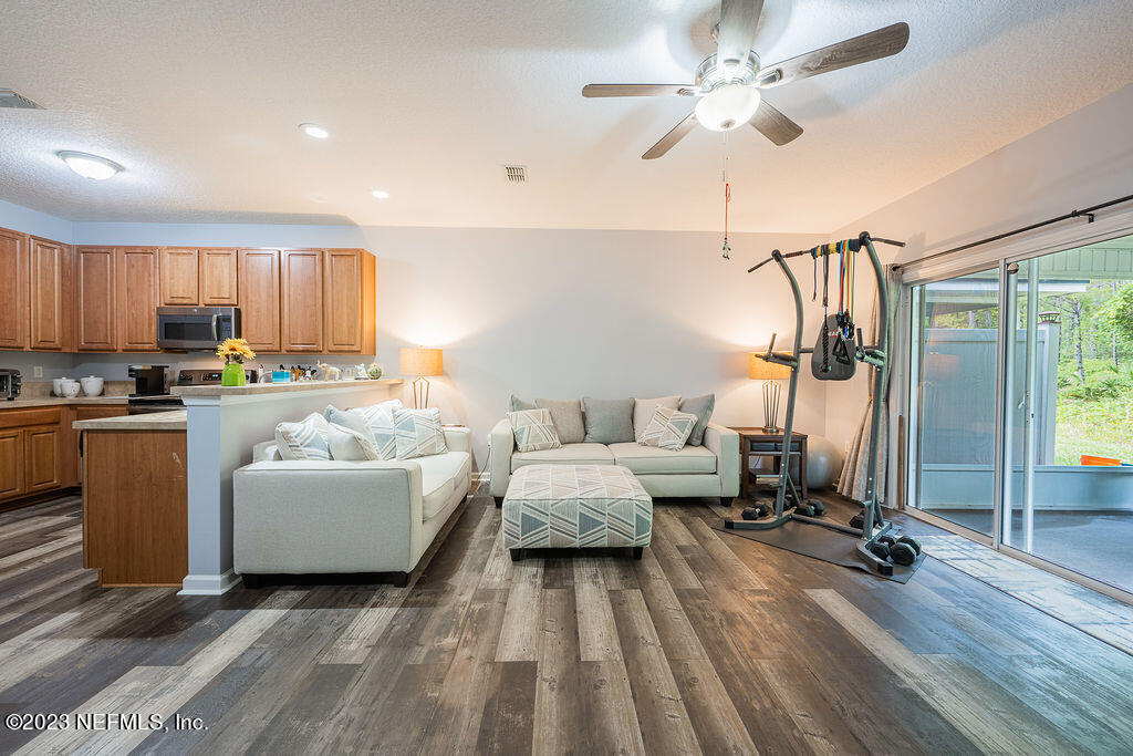 8683 Ribbon Falls Lane Jacksonville, FL 32244 - Photo 14 of 43 a living room with furniture and a flat screen tv