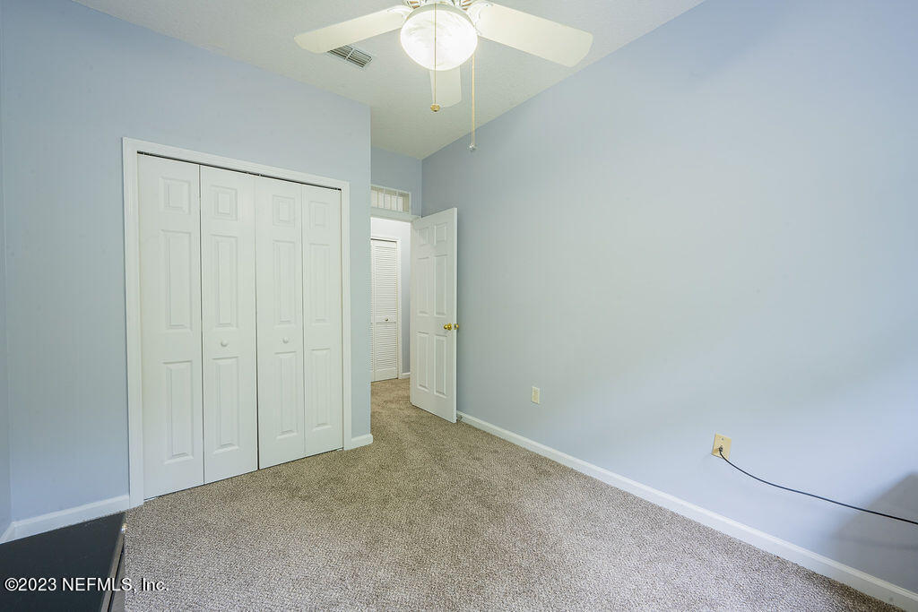 8683 Ribbon Falls Lane Jacksonville, FL 32244 - Photo 15 of 43 an empty room with a chandelier fan