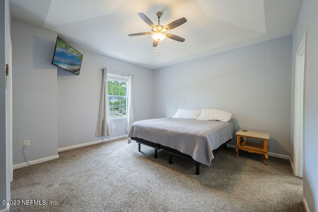 8683 Ribbon Falls Lane Jacksonville, FL 32244 - Photo 16 of 43 a spacious bedroom with a bed and a ceiling fan