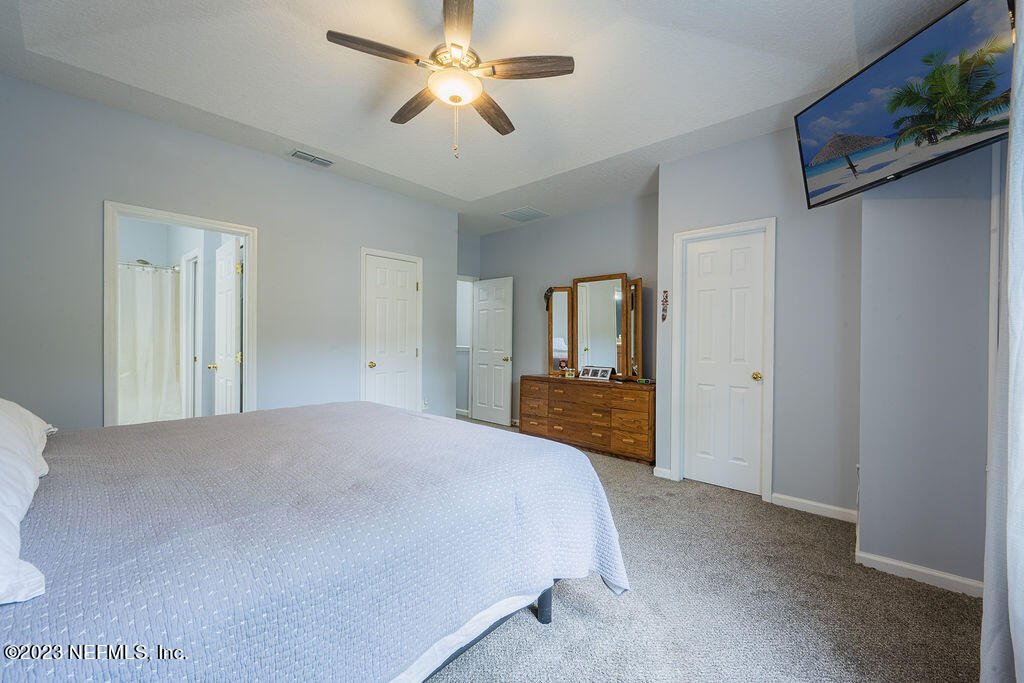 8683 Ribbon Falls Lane Jacksonville, FL 32244 - Photo 17 of 43 a spacious bedroom with a bed and a chandelier