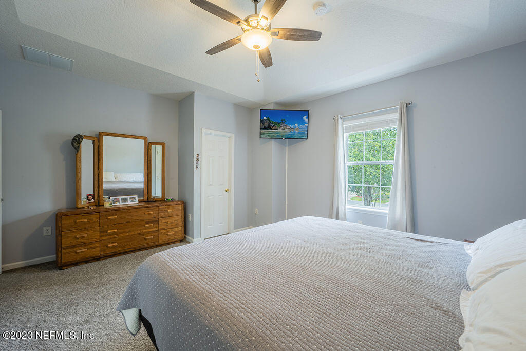 8683 Ribbon Falls Lane Jacksonville, FL 32244 - Photo 30 of 43 a bedroom with a bed and dresser with mirror