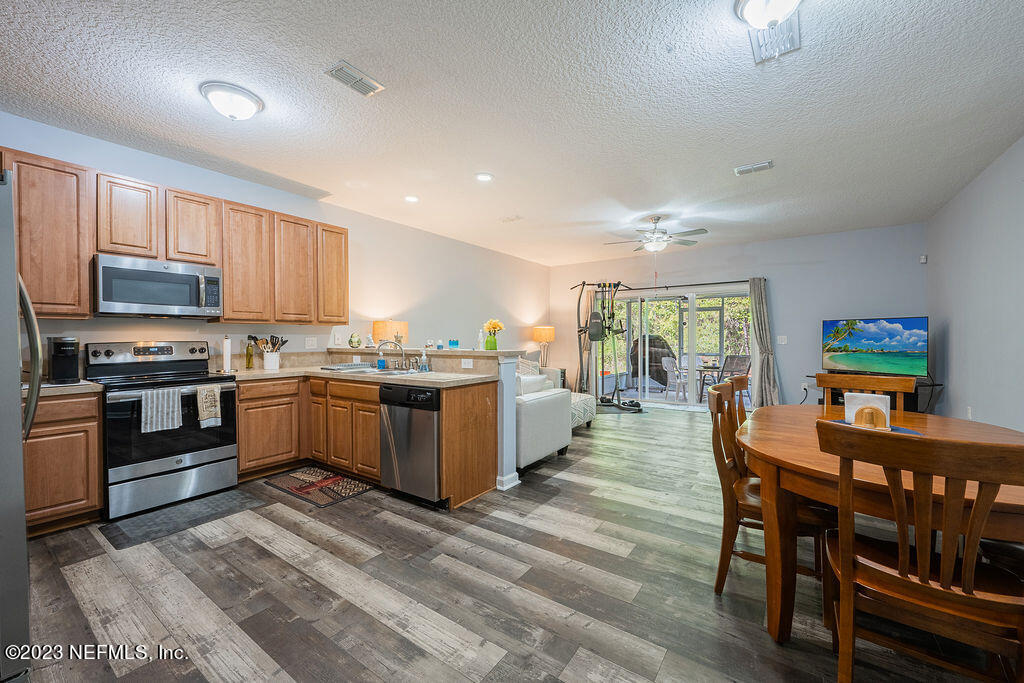 8683 Ribbon Falls Lane Jacksonville, FL 32244 - Photo 3 of 43 a kitchen with a table chairs microwave and cabinets