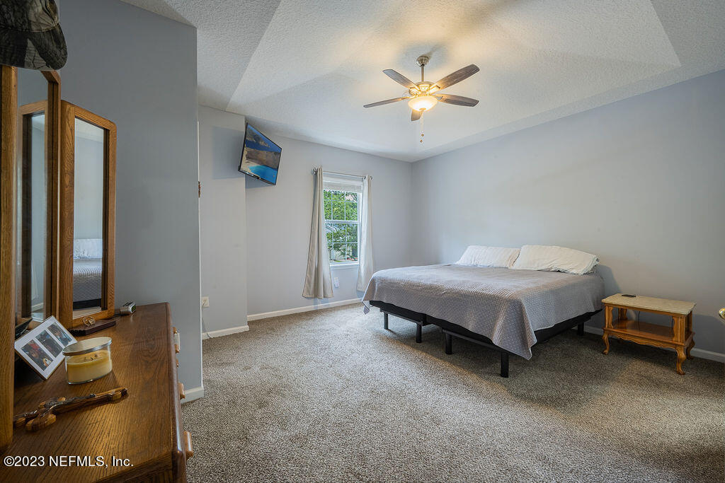 8683 Ribbon Falls Lane Jacksonville, FL 32244 - Photo 5 of 43 a spacious bedroom with a bed and a chandelier