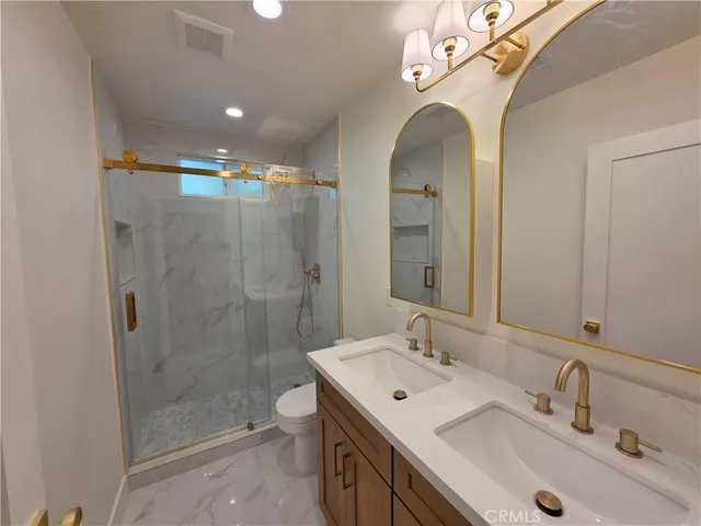 a bathroom with a double vanity sink mirror and toilet