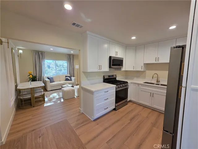 a kitchen with stove cabinets and wooden floor