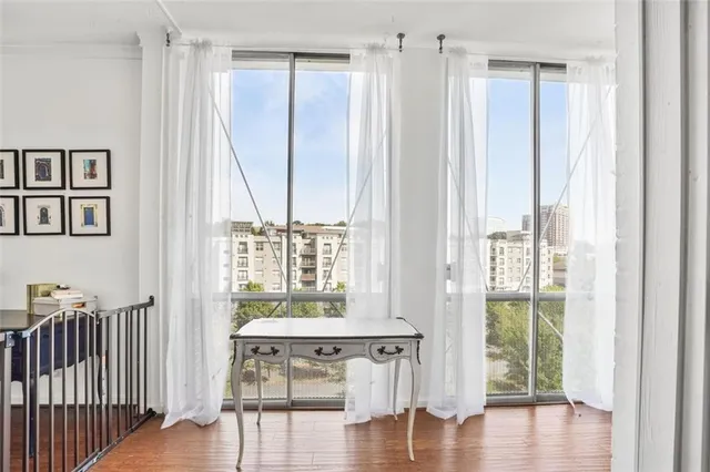 a view of a room with wooden floor windows and front door