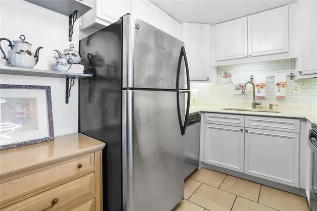 a kitchen with a refrigerator sink and cabinets
