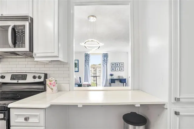 a kitchen with a sink and a stove with white countertops