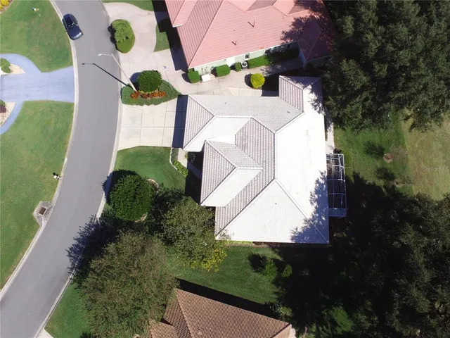 an aerial view of a house with a yard and greenery