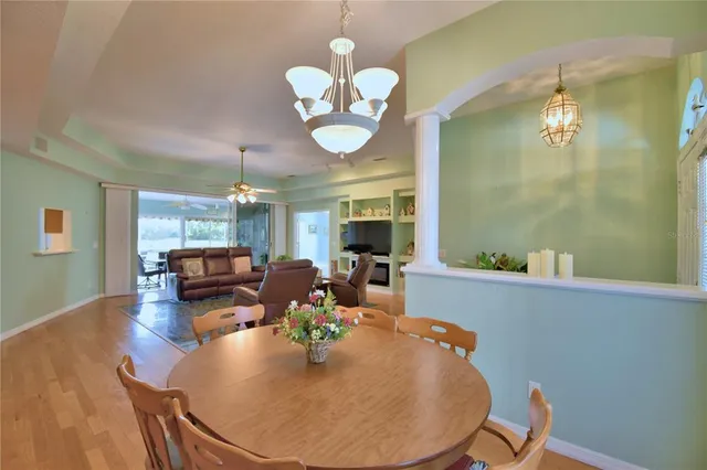 a view of a livingroom with furniture a chandelier and wooden floor