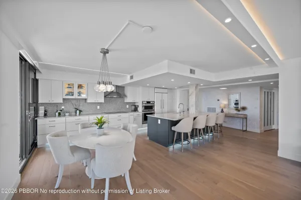 a dining room with kitchen island stainless steel appliances furniture a dining table and chairs