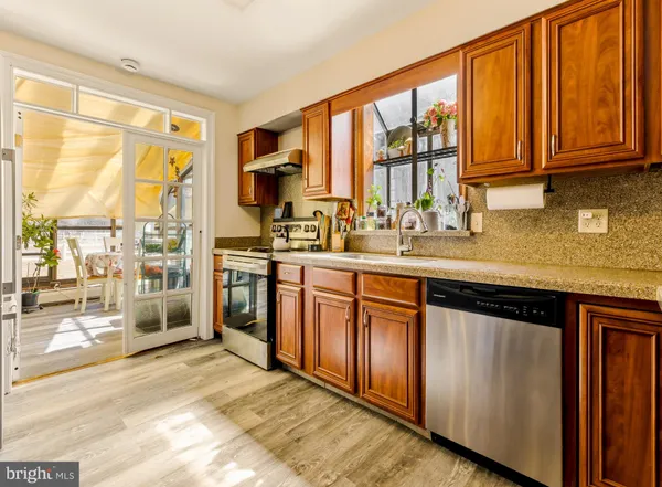 a kitchen with stainless steel appliances granite countertop a stove a sink and a refrigerator