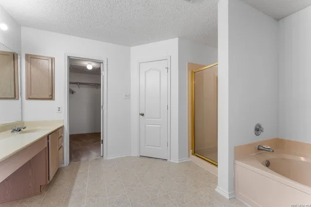 a bathroom with a tub a sink and mirror