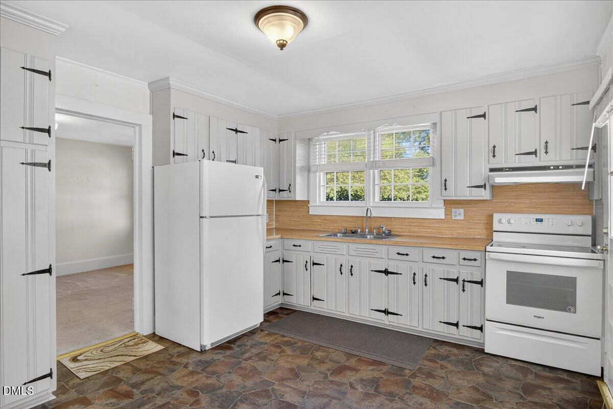 616 Roxboro Road Oxford, NC 27565 - Photo 4 of 38 a kitchen with granite countertop white cabinets white appliances a sink and a refrigerator
