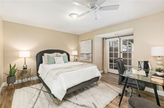 a bedroom with a bed a table and with potted plants