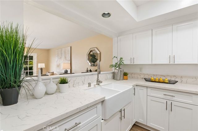 a kitchen with a sink and white cabinets