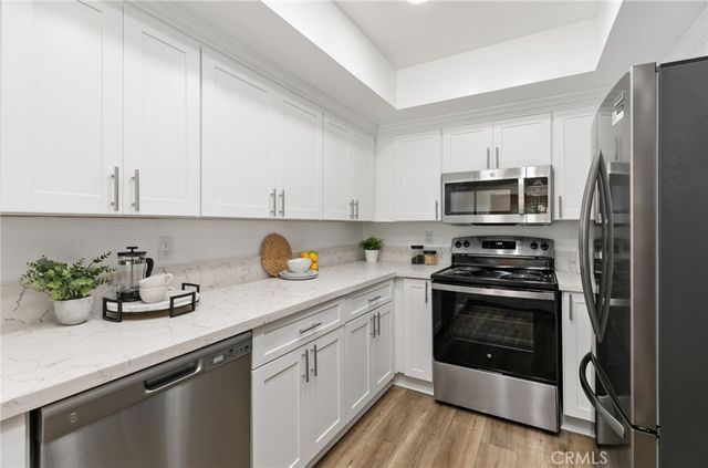 a kitchen with a sink white cabinets and stainless steel appliances