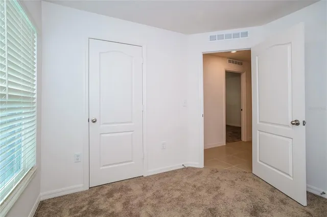 an empty room with closet and a bathroom