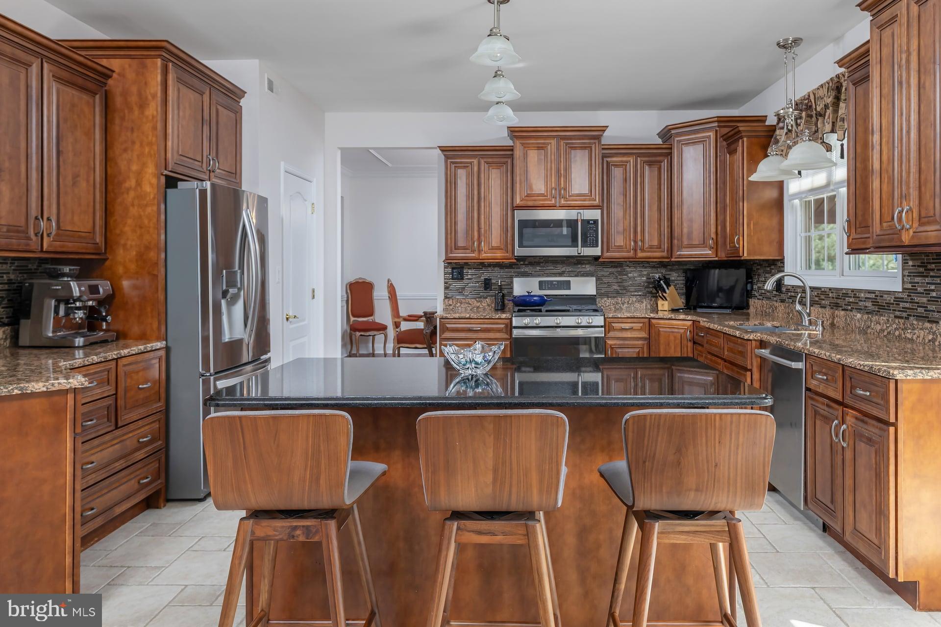144 Point Airy Road Pilesgrove, NJ 08098 - Photo 12 of 65 a kitchen with stainless steel appliances granite countertop a stove top oven a sink dishwasher a dining table and chairs with wooden floor