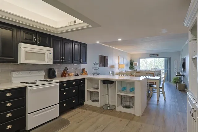 a kitchen with a sink a stove a refrigerator and cabinets