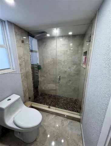 a bathroom with a toilet and a shower