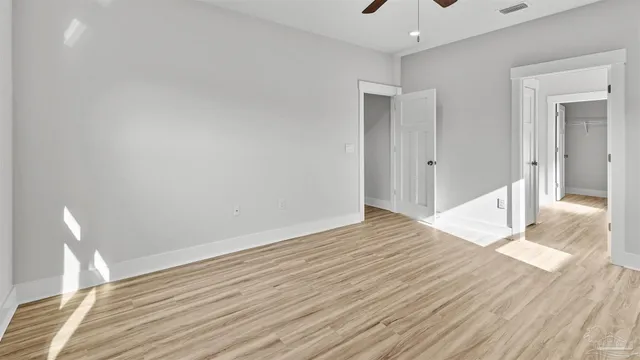 a view of empty room with wooden floor