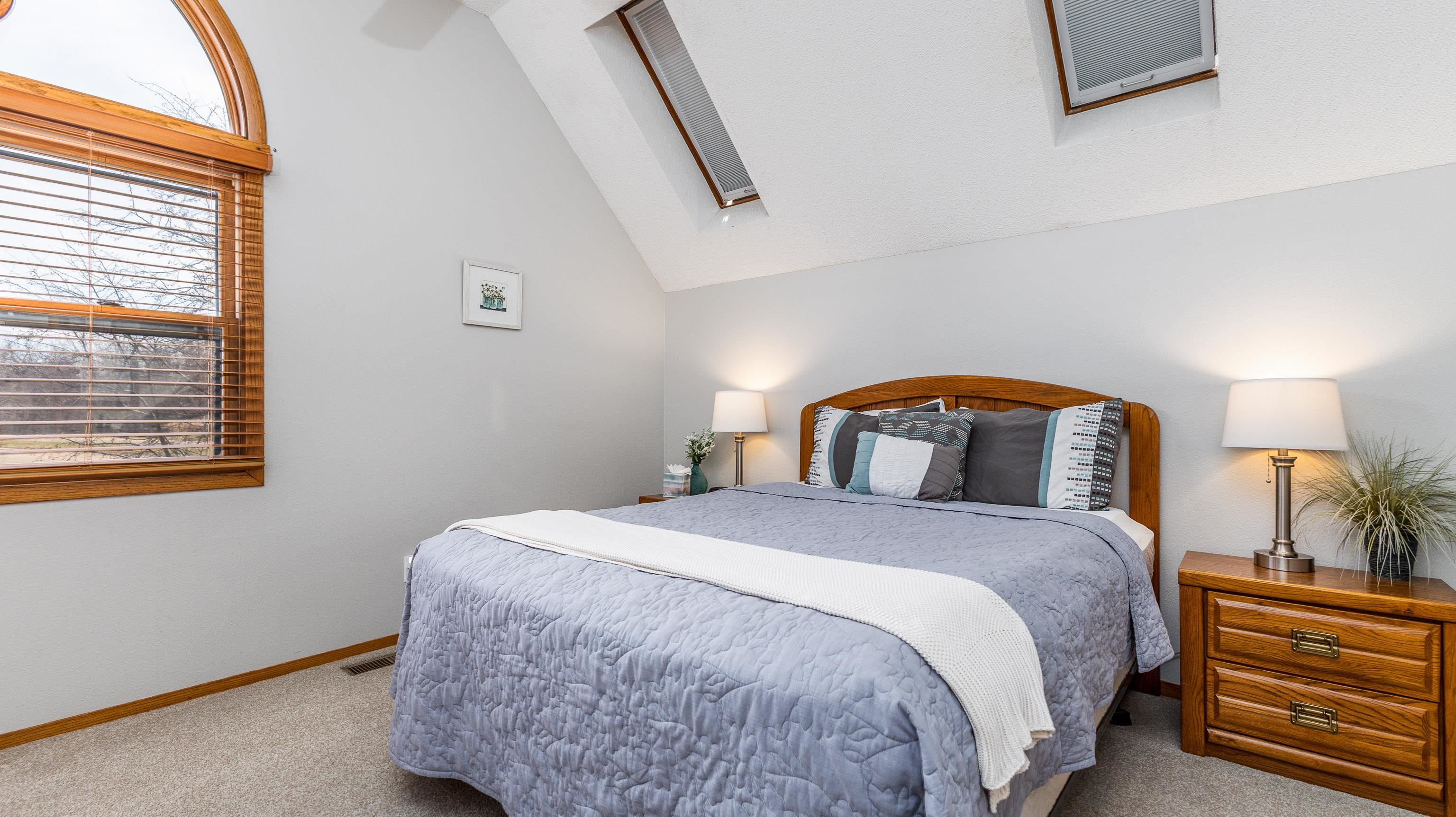 7 Colony Lane Galena, IL 61036 - Photo 17 of 36 a bedroom with a bed a lamp and window