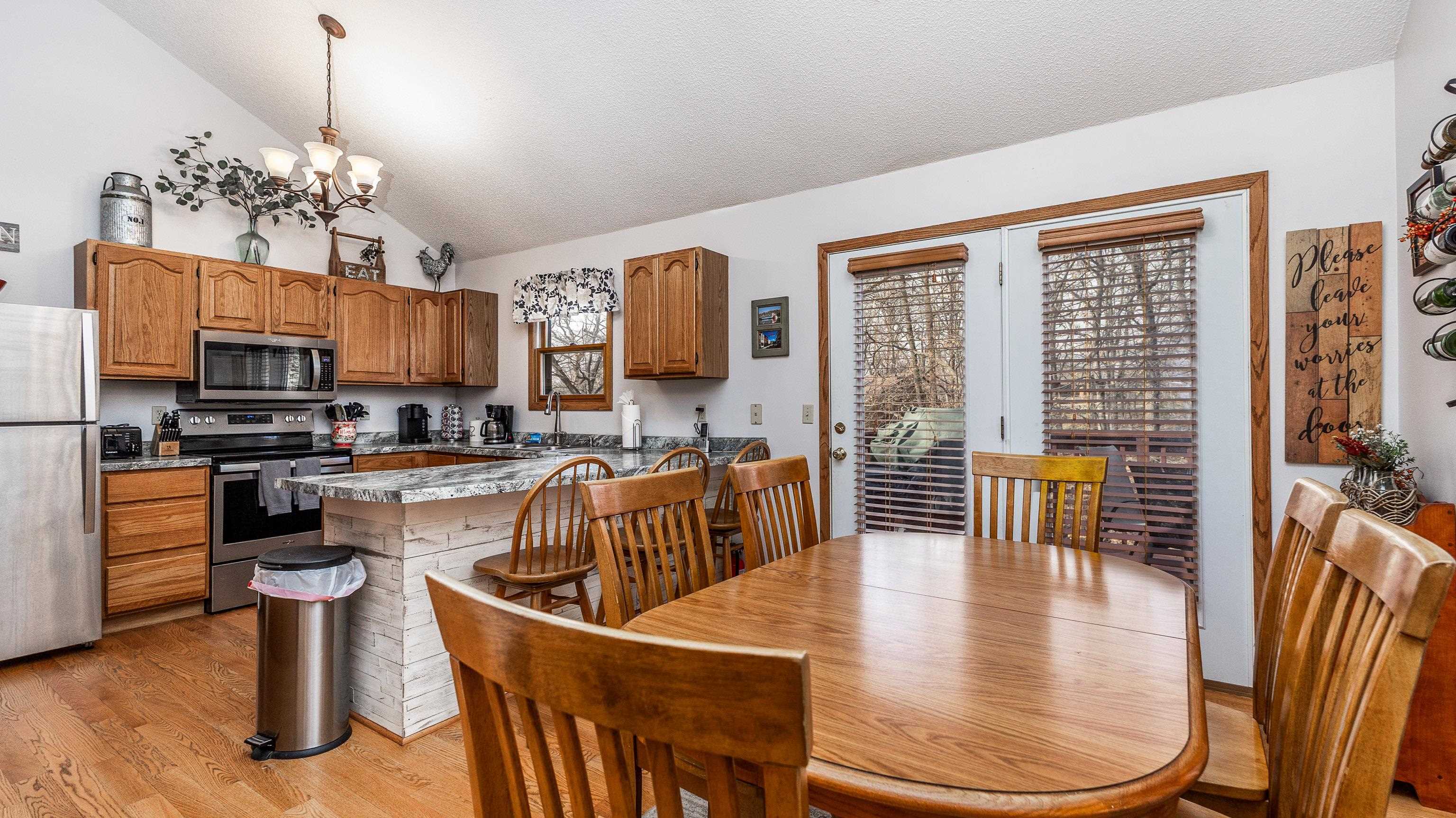 7 Colony Lane Galena, IL 61036 - Photo 7 of 36 a dining room with wooden floor a glass table and chairs