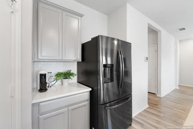 a kitchen with metallic refrigerator freezer and a dishwasher