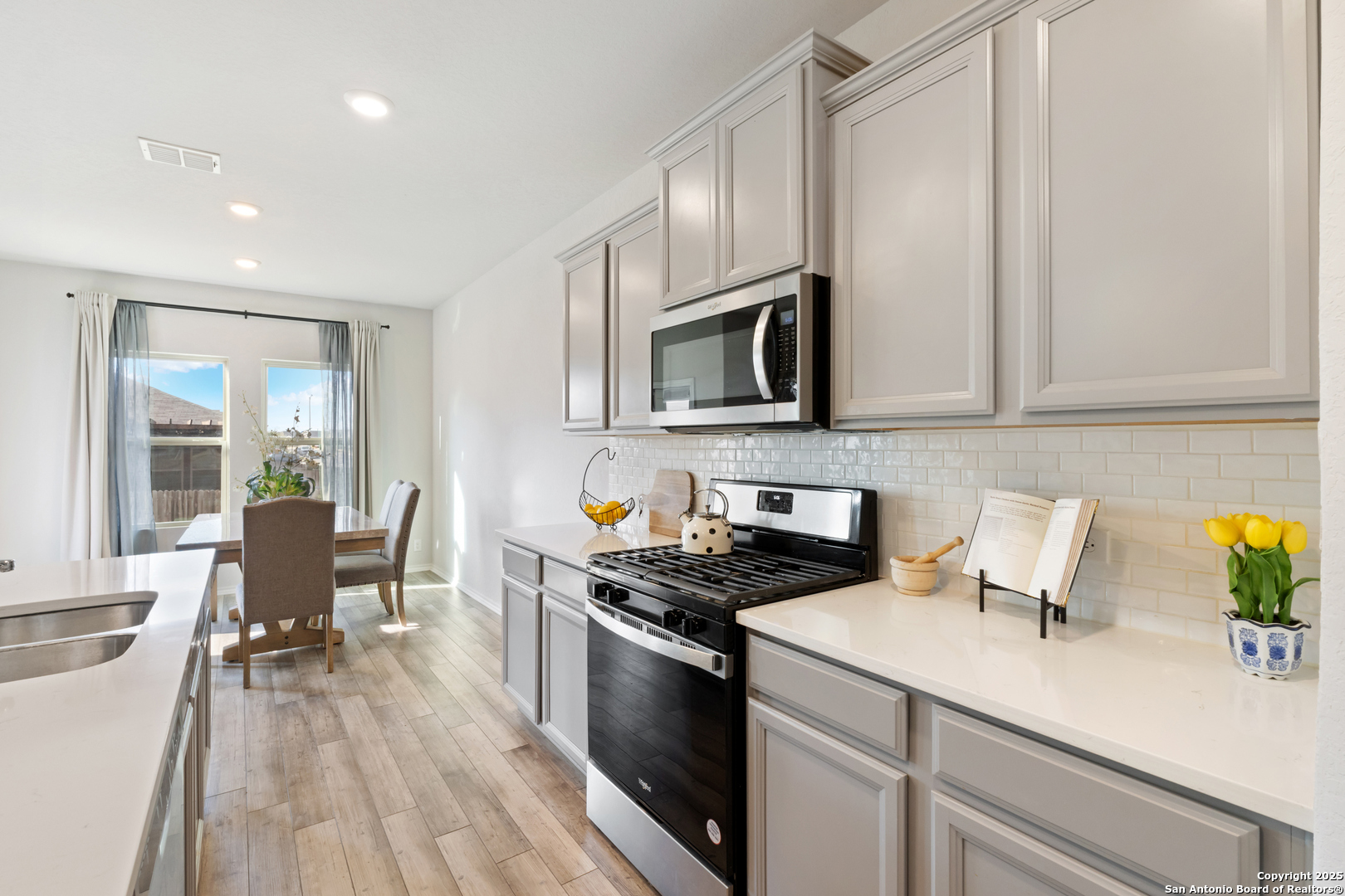 6847 Alaskan Wy. Converse, TX 78109 - Photo 13 of 32 a kitchen with granite countertop a sink a stove top oven and cabinetry