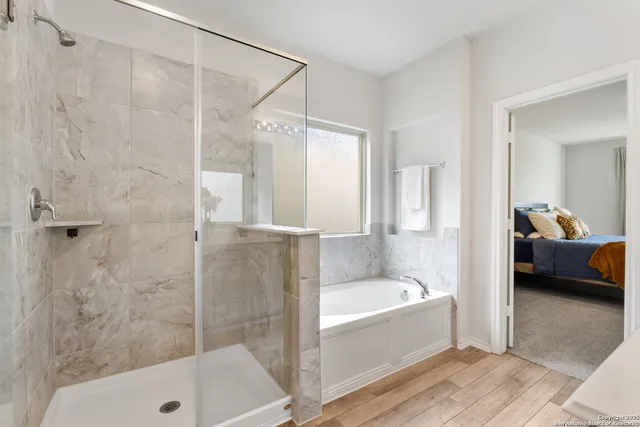 a bathroom with a tub shower and sink
