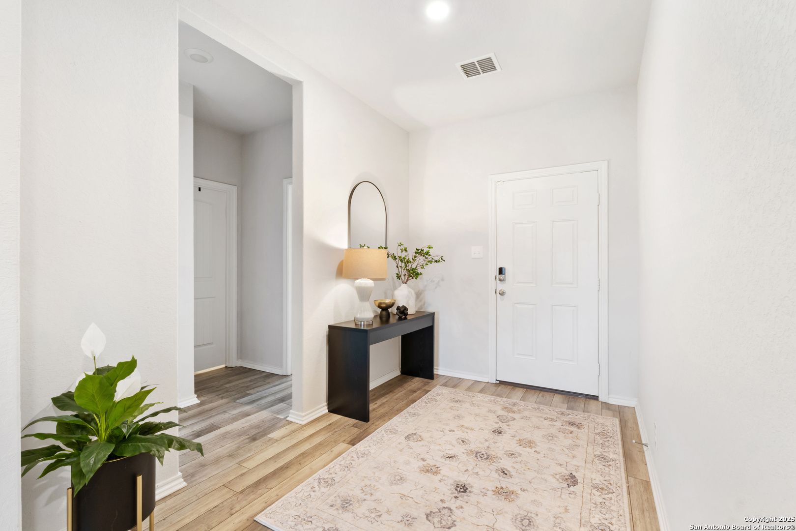 6847 Alaskan Wy. Converse, TX 78109 - Photo 4 of 32 a view of a hallway with wooden floor and a potted plant