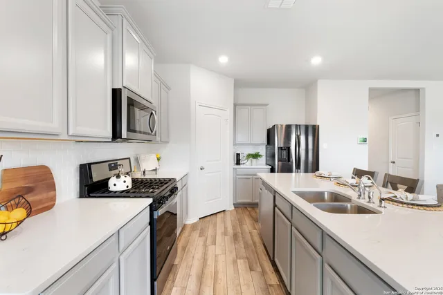 a kitchen with a sink a stove and cabinets