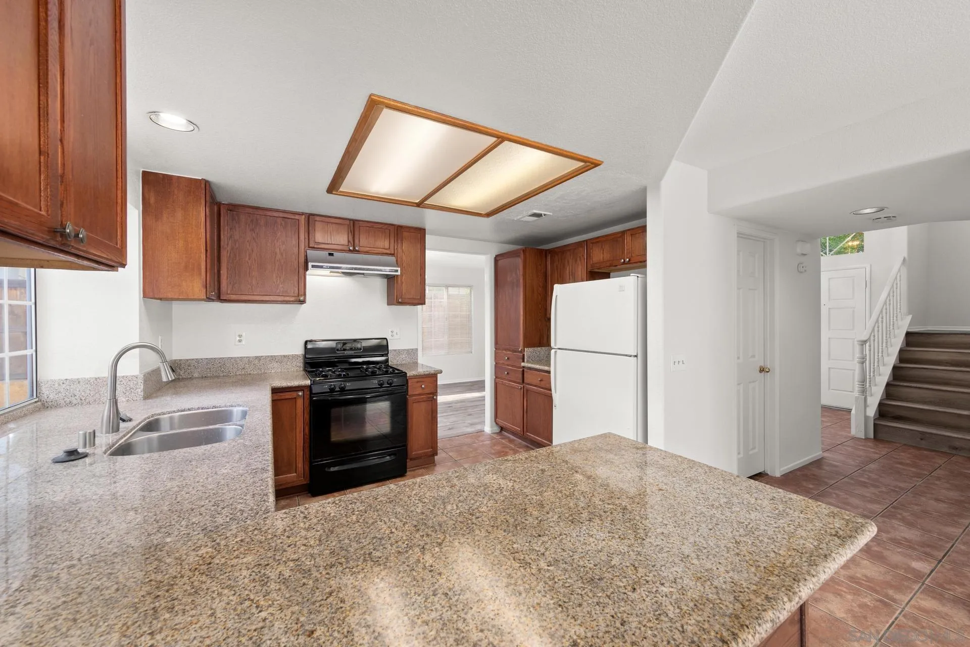 403 Calle Corazon Oceanside, CA 92057 - Photo 14 of 40 a kitchen with granite countertop a stove and a refrigerator