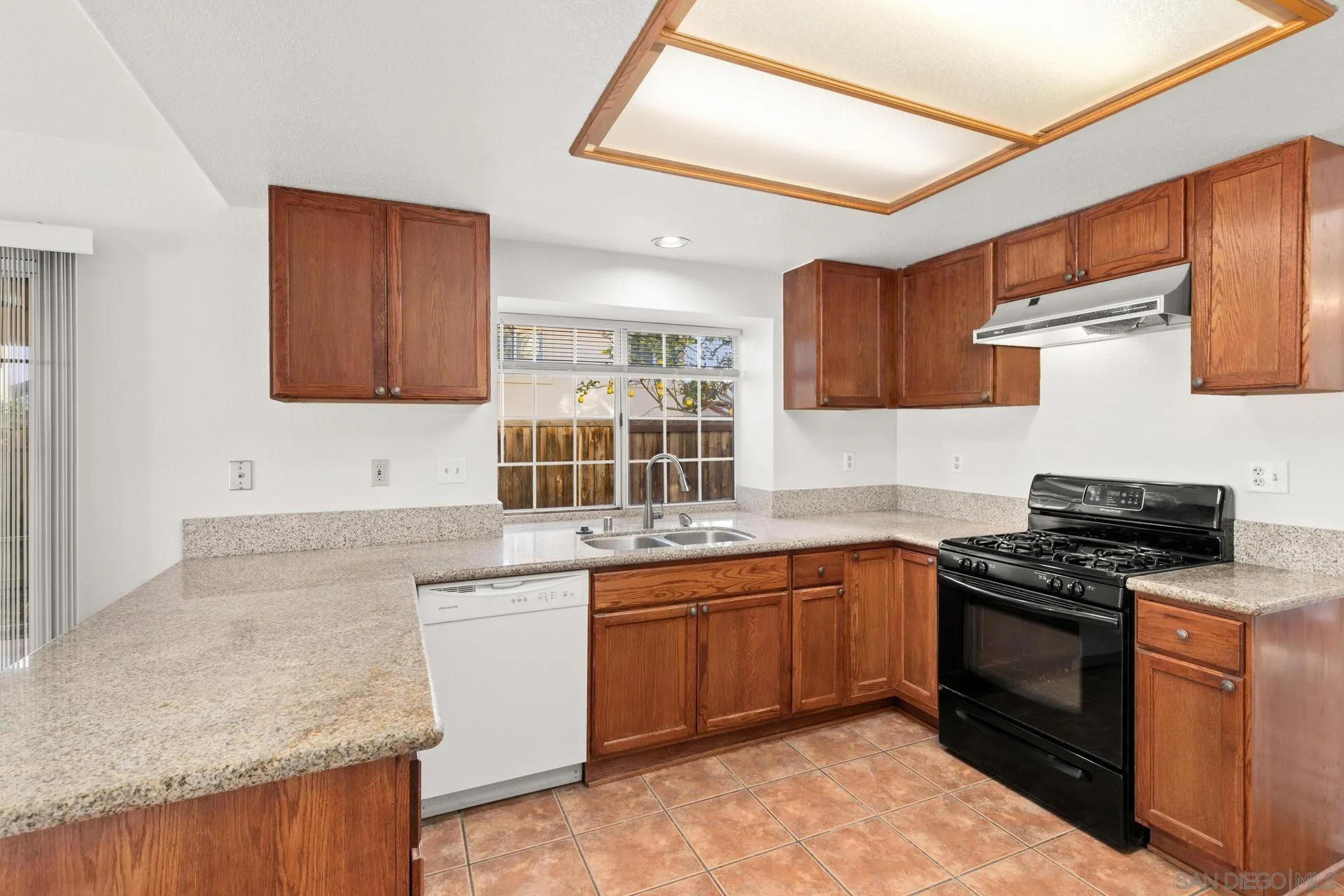 403 Calle Corazon Oceanside, CA 92057 - Photo 15 of 40 a kitchen with stainless steel appliances granite countertop wooden cabinets stove top oven and sink