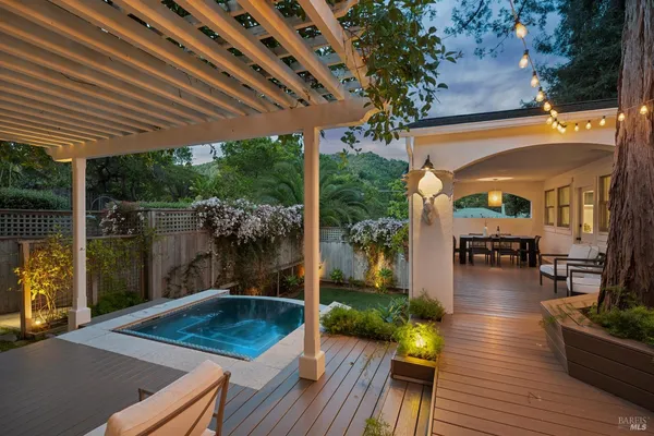 a view of a patio with table and chairs potted plants and floor to ceiling window