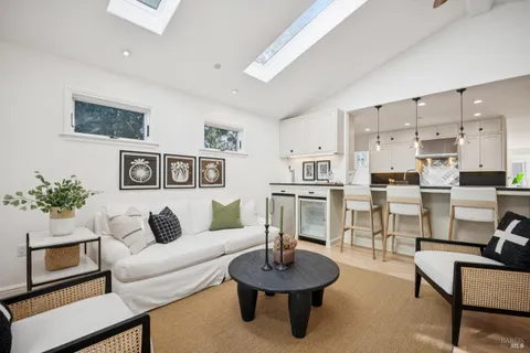 a living room with furniture and a view of kitchen