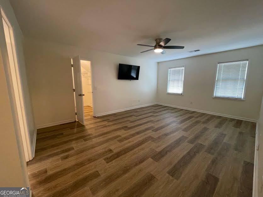 1502 Eryn Circle Suwanee, GA 30024 - Photo 18 of 57 an empty room with wooden floor ceiling fan and windows