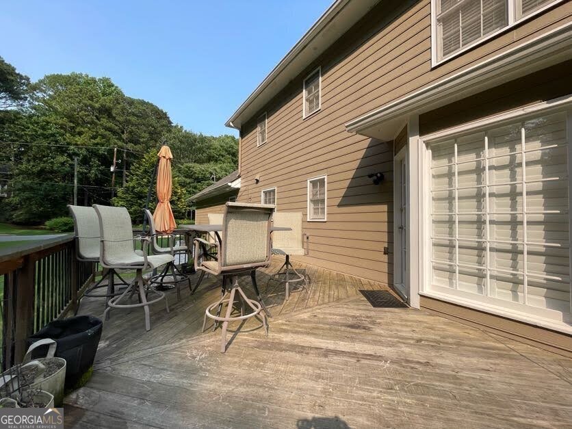 1502 Eryn Circle Suwanee, GA 30024 - Photo 52 of 57 a view of a patio with table and chairs with wooden floor and fence