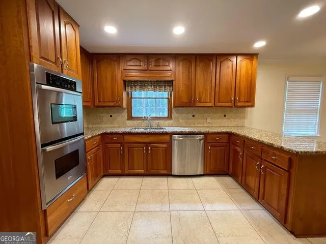 a kitchen with stainless steel appliances granite countertop a stove a sink and a microwave
