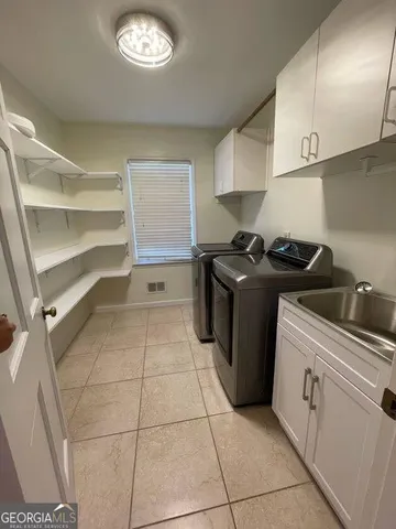 a kitchen with sink a stove and cabinets