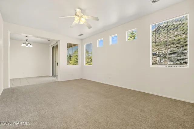 a living room with furniture a chandelier and a flat screen tv