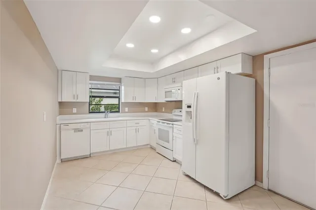 a kitchen with white cabinets and white appliances