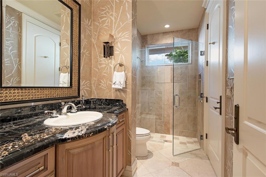 14906 Bellezza Lane Naples, FL 34110 - Photo 12 of 33 a bathroom with a granite countertop sink a toilet a mirror and shower