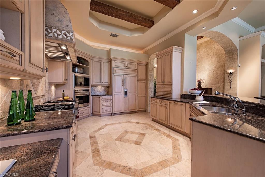 14906 Bellezza Lane Naples, FL 34110 - Photo 15 of 33 a large kitchen with kitchen island a large counter top stainless steel appliances and cabinets